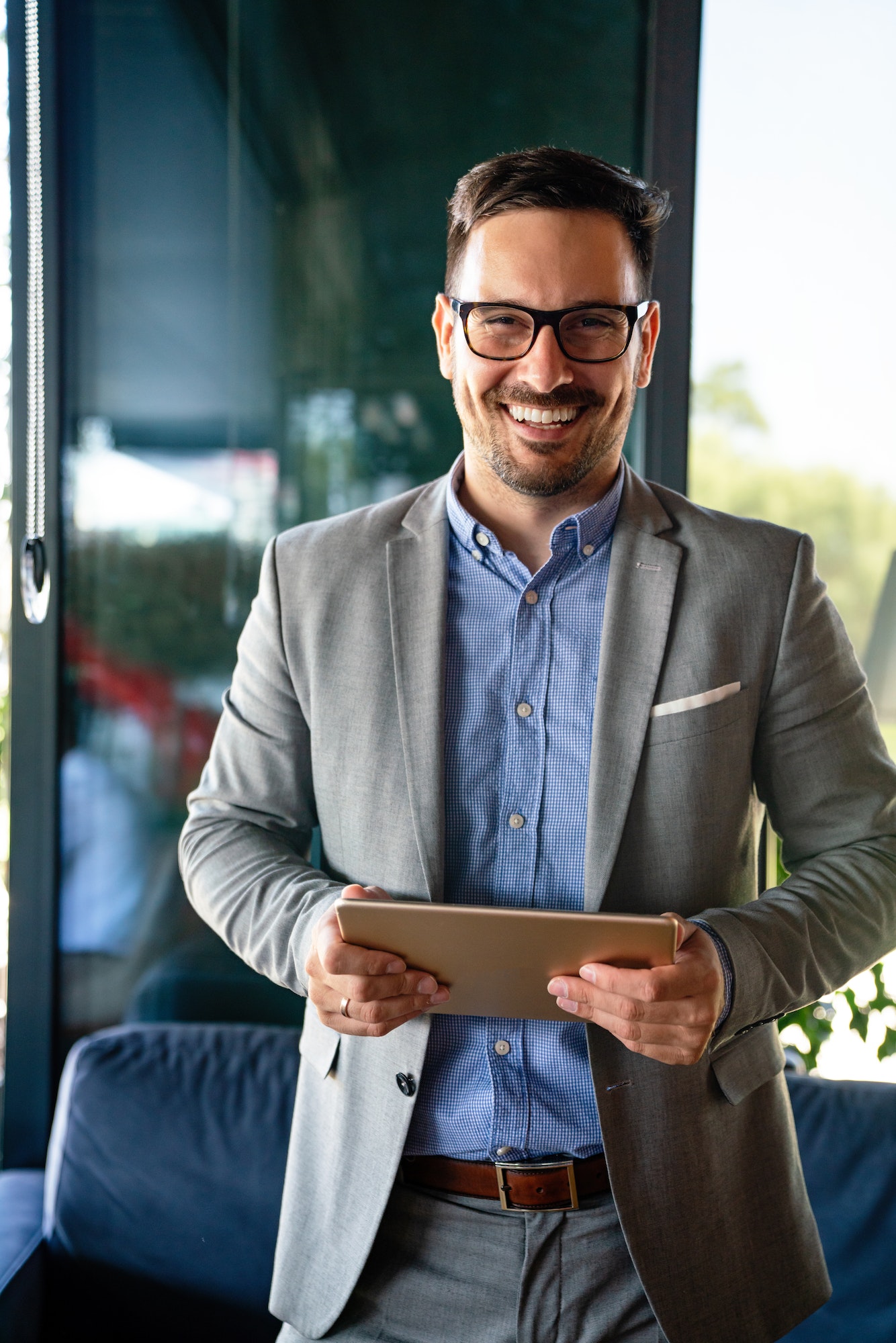 Portrait of happy succeffsul young business man, leader, ceo, manager using digital tablet to work